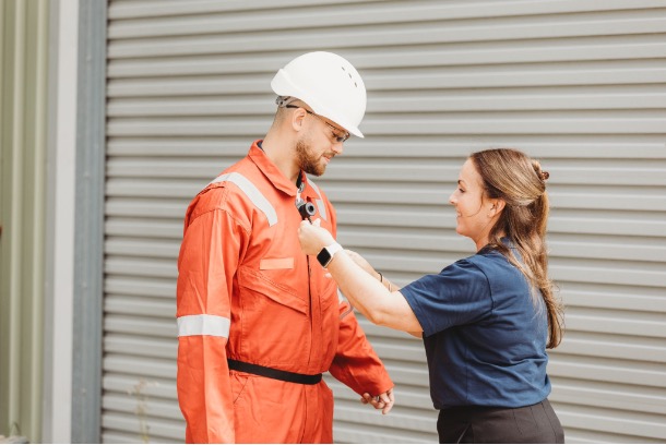 Armstrong Environmental occupational hygienist fitting personal air-sampling equipment to a worker