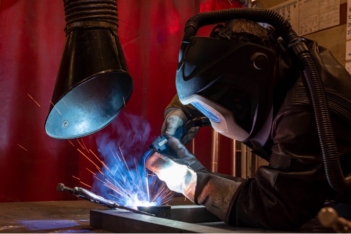 Welder working beneath a local exhaust ventilation extraction hood