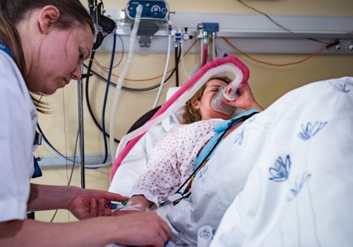 Pregnant woman preparing for delivery, getting help from nurse.