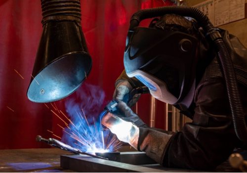 Welder working beneath a local exhaust ventilation extraction hood